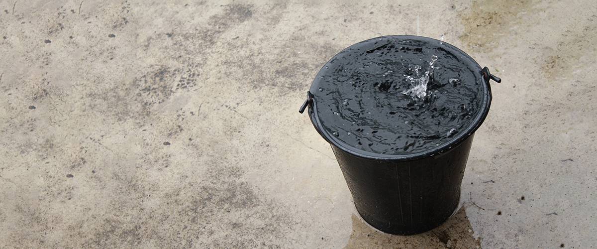 a leak bucket on top of a concrete roof