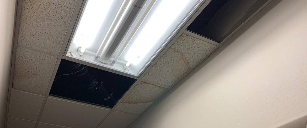 A photo of a leak stain on a ceiling with drop-tile