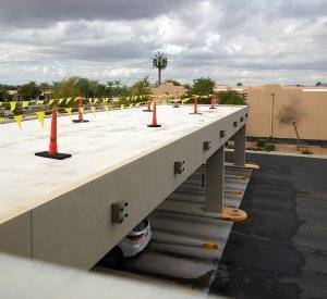 roof coating application on a flat roof. yellow flags strung between orange cones on the roof for protection and safety